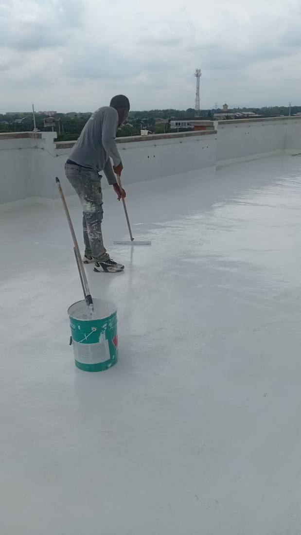 Operario aplicando el recubrimiento de poliuretano con rodillo sobre una terraza