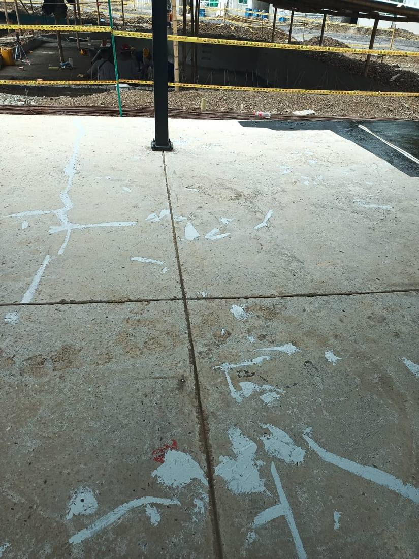 Losa de concreto con las primeras fisuras marcadas y selladas en blanco