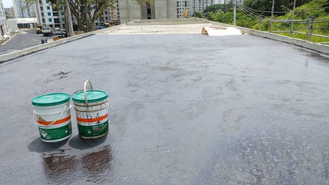 Cubierta con imprimación aplicada y baldes de producto listos para la pega del manto
