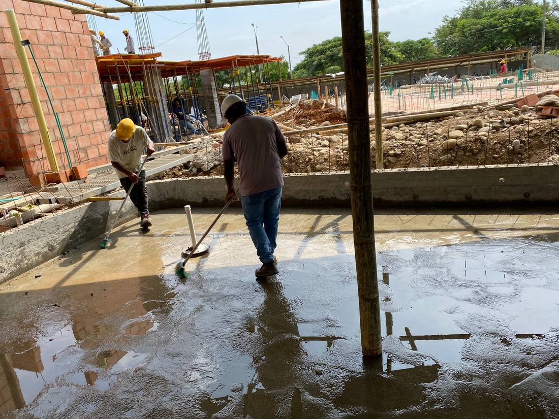 Operarios extendiendo mortero para el alistamiento de la superficie de una piscina